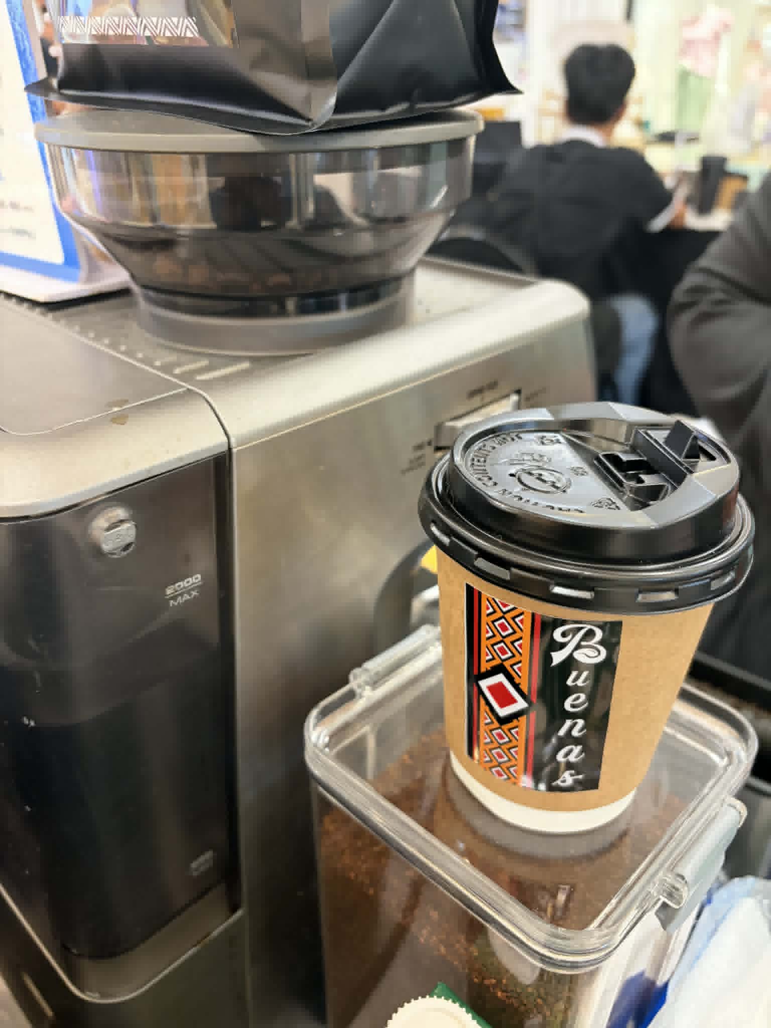 A Simbalan cup on the counter beside the grinder
